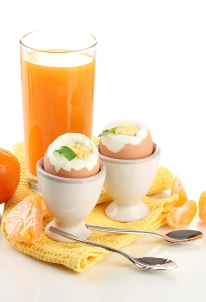 Leichtes Frühstück mit gekochten Eiern und einem Glas Saft, isoliert auf weiß — Stockfoto