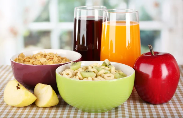 Cereais deliciosos e saudáveis em tigelas com suco e frutas na mesa no quarto — Fotografia de Stock