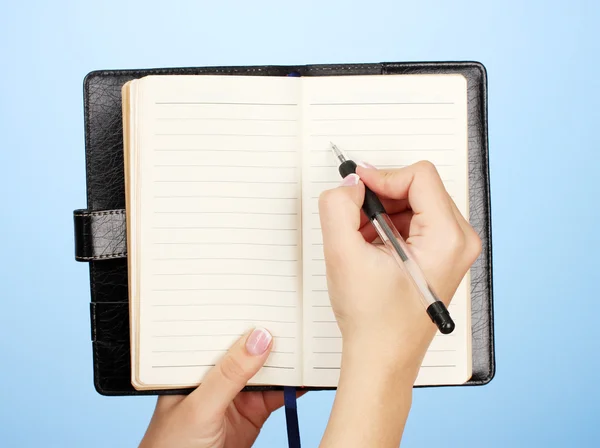 Mão escrever no notebook, no fundo de cor — Fotografia de Stock