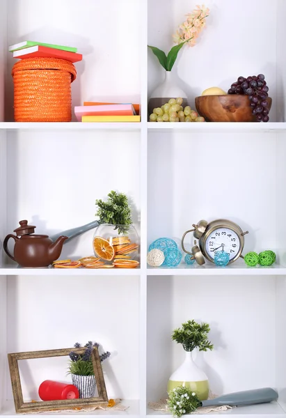Schöne weiße Regale mit verstreuten verschiedenen häuslichen Objekten — Stockfoto