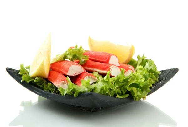 Paus de caranguejo com folhas de alface e limão em prato isolado em branco — Fotografia de Stock