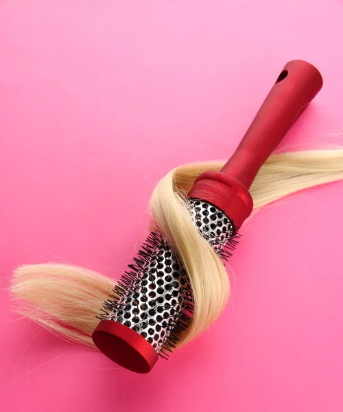 Comb brush with hair, on pink background — Stock Photo, Image