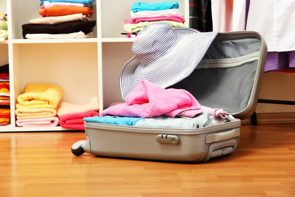 Otevřít stříbrný kufr s oblečením v místnosti — Stock fotografie