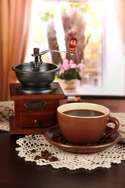 Cup of coffee with scarf and coffee mill on table in room — Stock Photo, Image