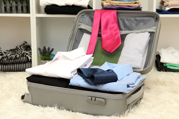 Valise ouverte grise avec vêtements dans la chambre — Photo