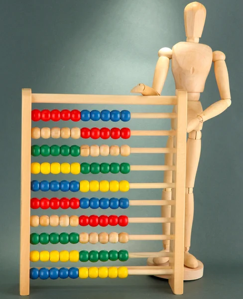Heldere speelgoed abacus en houten pop, op grijze achtergrond — Stockfoto