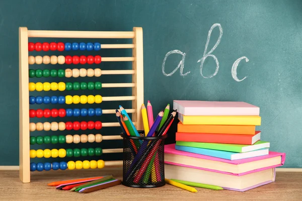 Leksak abacus, böcker och pennor på bord, på skolan skrivbord bakgrund — Stockfoto