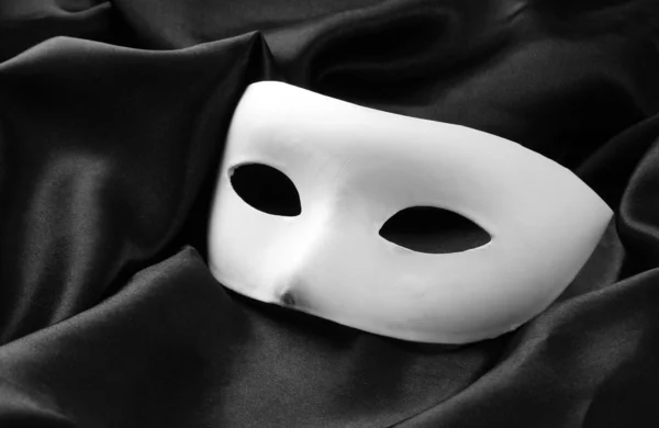 Wit masker, op zwarte zijden stof — Stockfoto