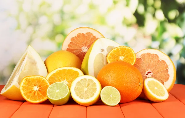 Veel rijp citrus op houten tafel op natuurlijke achtergrond — Stockfoto