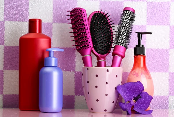 Hair brushes and cosmetic bottles in bathroom — Stock Photo, Image