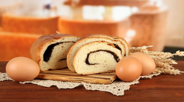 Loaf with poppy seed on cutting board, on bright background — Stock Photo, Image