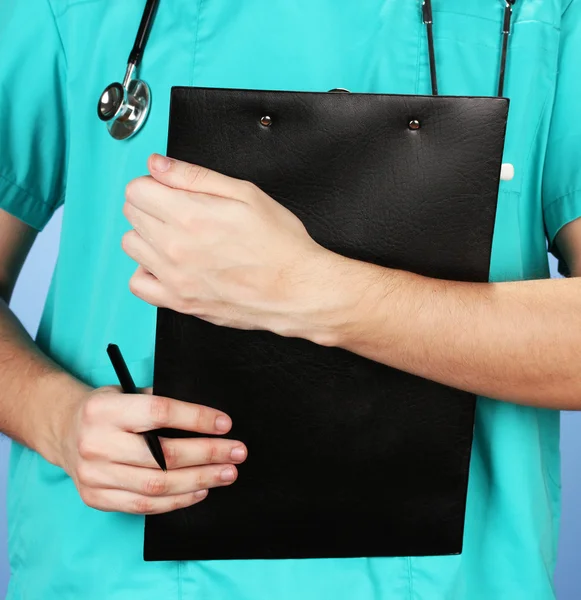 Mão de médico com prescrição em branco, em fundo azul — Fotografia de Stock