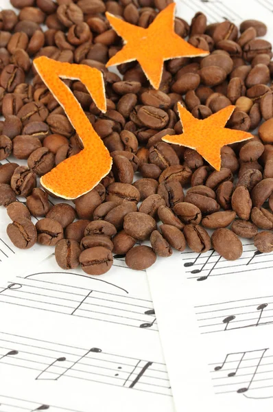 Decorative stars from dry orange peel with coffee beans on musical notes — Stock Photo, Image