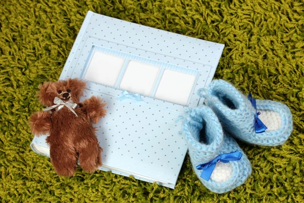 Baby photo album on green carpet — Stock Photo, Image