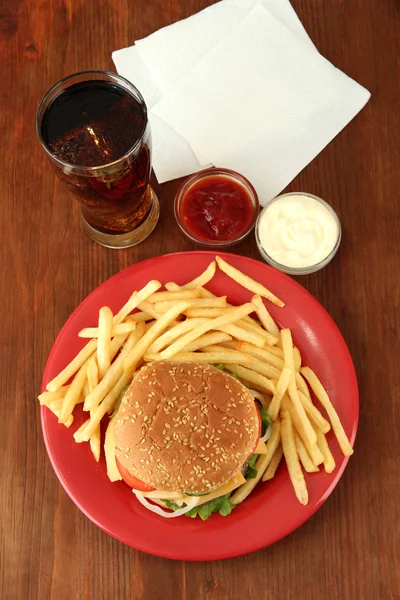 Patates kızartması ve ahşap zemin üzerinde soğuk içecek ile lezzetli peynirli burger — Stok fotoğraf
