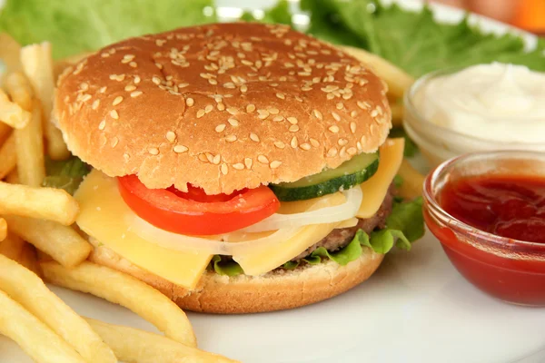 Burger keju lezat dengan kentang goreng, di latar belakang cerah — Stok Foto