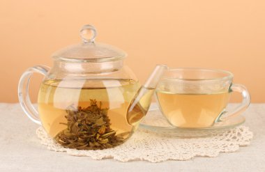 Tablo renkli arka plan üzerinde cam çaydanlık çiçeklerle egzotik yeşil çay