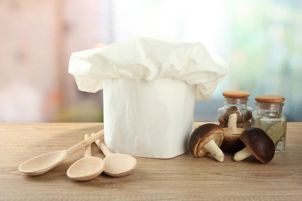 Kucharski kapelusik z łyżki na stole w kuchni — Zdjęcie stockowe