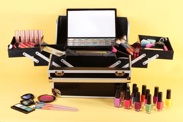 Open case with cosmetics on yellow background — Stock Photo, Image