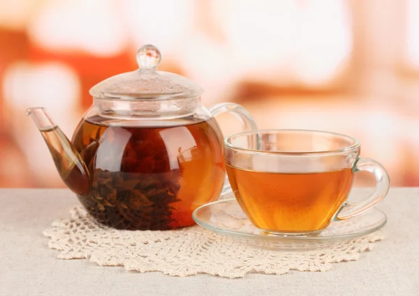 Exotic green tea with flowers in glass teapot on bright background — Stock Photo, Image