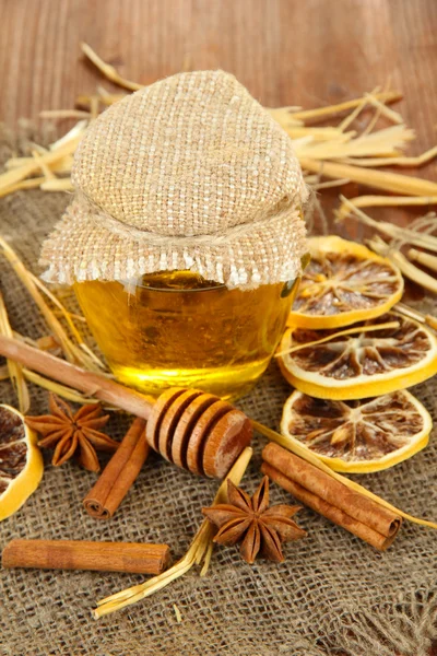 Jar of honey, drizzler and dried lemons on wooden background — Stock Photo, Image