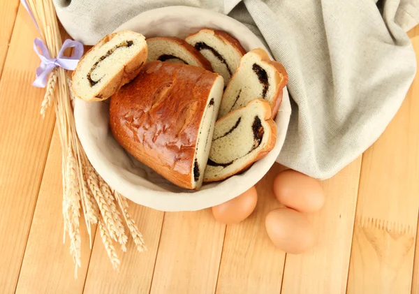 Хліб з маком у плетеному кошику, на дерев'яному фоні — стокове фото