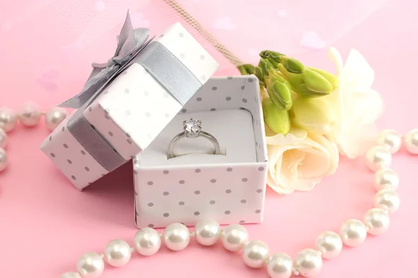 Beautiful box with wedding ring and flower on pink background — Stock Photo, Image