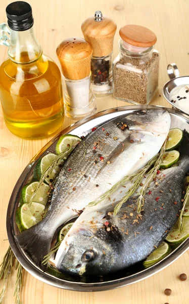 Two fish dorado with lemon on pan on wooden table close-up — Stock Photo, Image