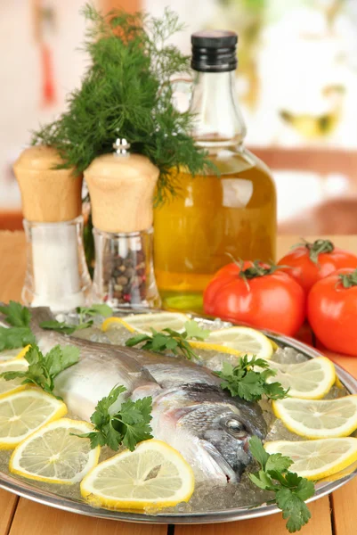 Dorado fresco en tajadera con limón y verduras en la mesa de madera — Stok fotoğraf