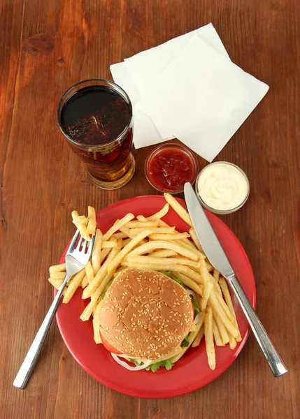 Smaczne cheeseburger z smażone ziemniaki i zimny napój, na tle drewniane — Zdjęcie stockowe