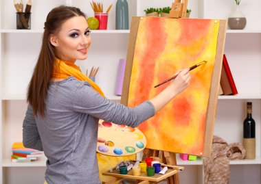 güzel bir genç kadın ressam oda iç arka planda iş başında