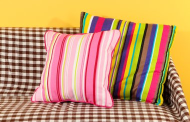 kanepede sarı arka plan üzerinde renkli yastıklar