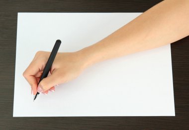 ahşap zemin üzerinde beyaz kağıt kalem ile el