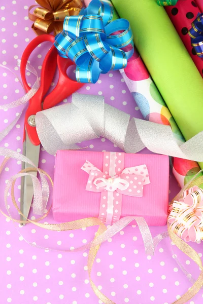 Rollos de papel de regalo de Navidad con cintas, lazos en el fondo de color —  Fotos de Stock