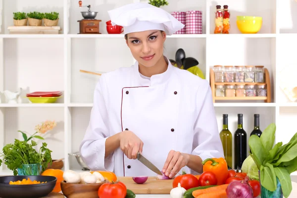 Young woman chef cooking in kitchen — Stock Photo, Image