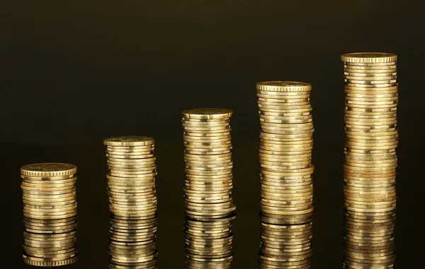 Many coins in columns on dark background — Stock Photo, Image