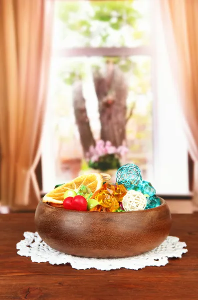 Torkade apelsiner, wicker bollar och andra hem dekorationer i trä skål, på ljus bakgrund — Stockfoto