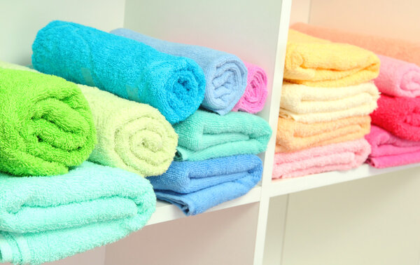 colorful towels on shelves in bathroom