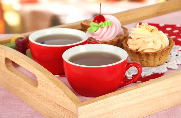 Xícaras de chá com bolos em bandeja de madeira na mesa no café — Fotografia de Stock