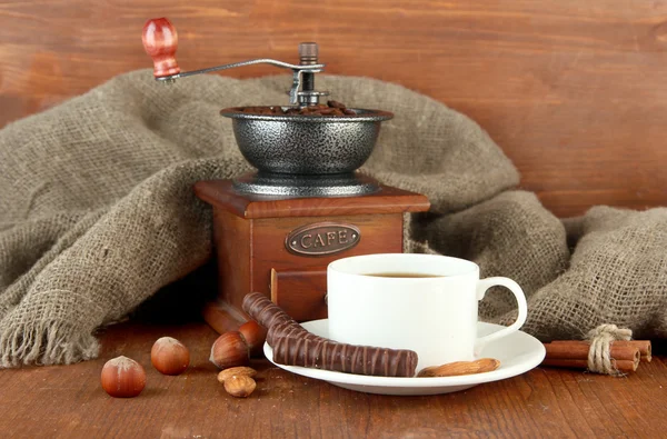 Chocolate escuro, bebida quente e moinho de café em fundo de madeira — Fotografia de Stock