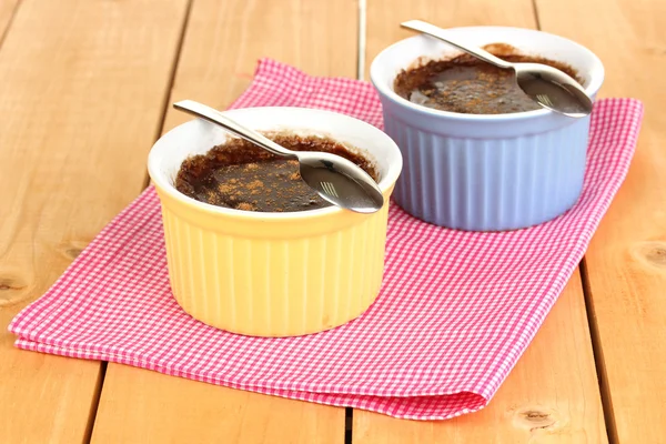 Budino al cioccolato in ciotole per la cottura su tavolo di legno — Foto Stock