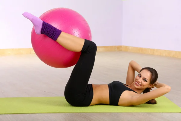 Jeune femme avec balle de gymnase au gymnase — Photo