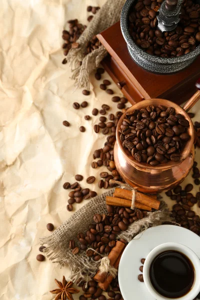 Tazza di caffè, pentola e macinino su sfondo beige — Foto Stock