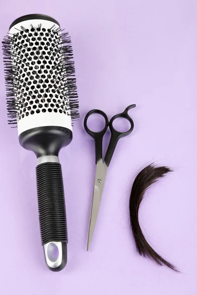 Morceaux de cheveux coupés avec des ciseaux sur fond violet — Photo