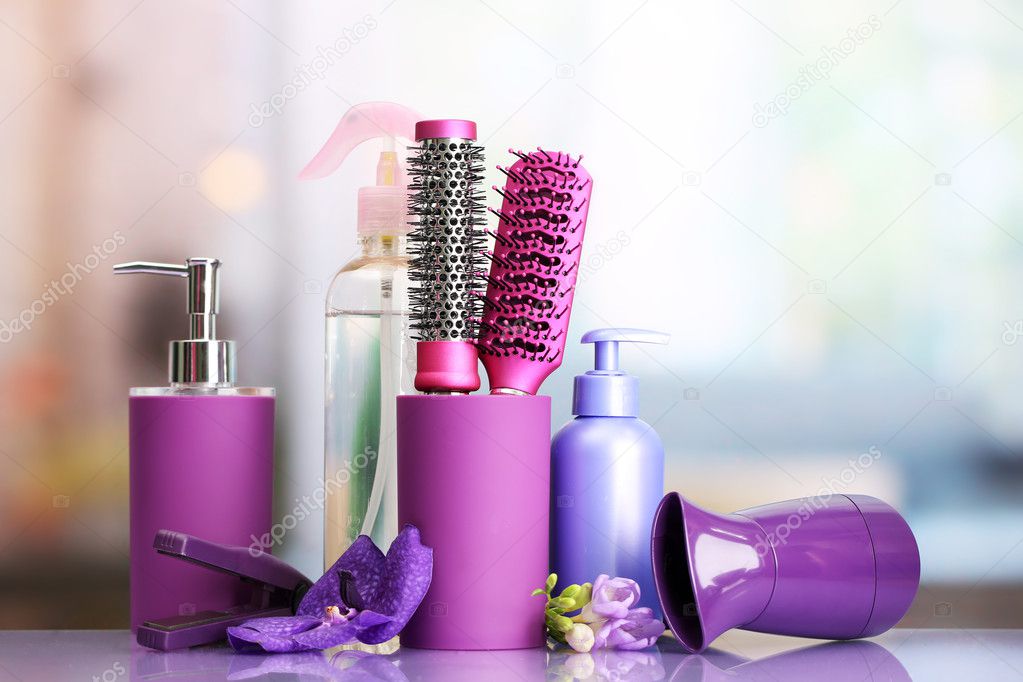 Hair brushes, hairdryer, straighteners and cosmetic bottles in beauty salon