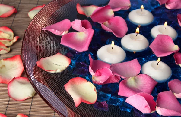 Pétales de roses et bougies dans l'eau en vase close-up — Photo