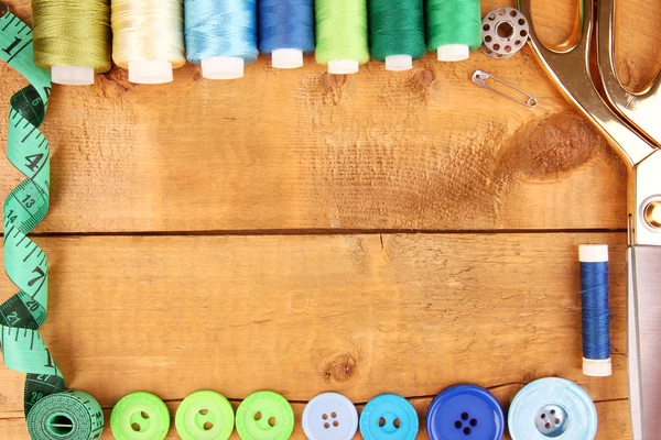 Naaien accessoires en stof op houten tafel close-up — Stockfoto