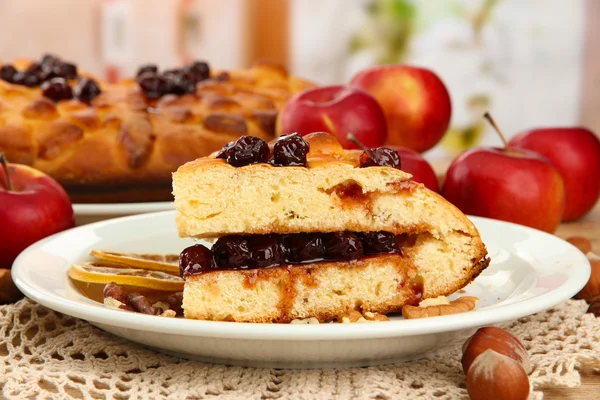 Scheibe leckerer hausgemachter Kuchen mit Marmelade und Äpfeln, auf Holztisch — Stockfoto