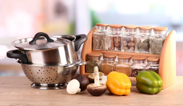 Skład narzędzia kuchenne, przyprawy i warzywa na stole w kuchni — Zdjęcie stockowe