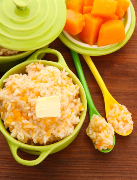 Pruebe la papilla de arroz con calabaza en cacerolas sobre fondo de madera —  Fotos de Stock